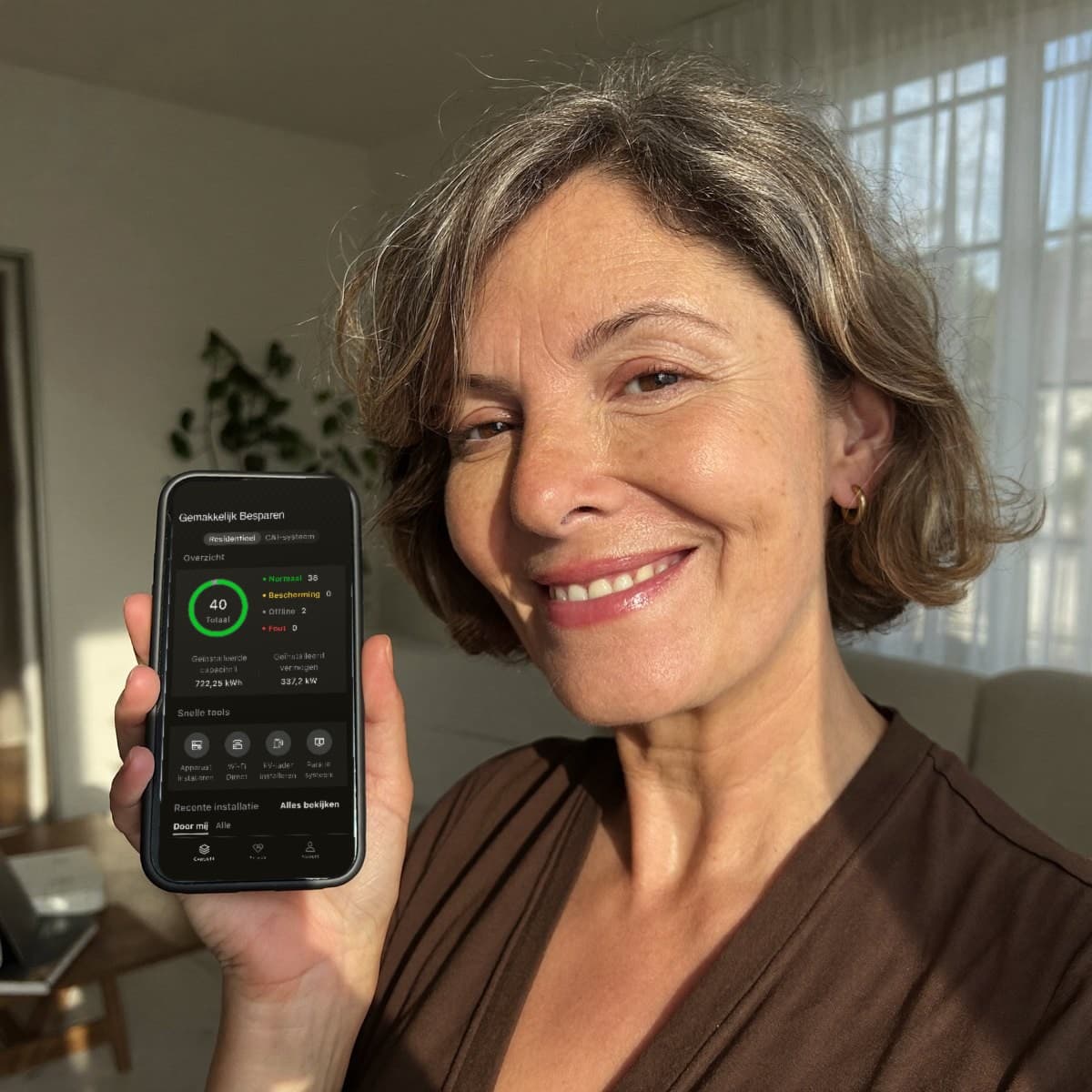 Klant laat op haar telefoon de app zien waarin het systeem op afstand wordt gevolgd